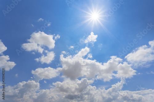 hot sparkle sun on blue cloudy sky background