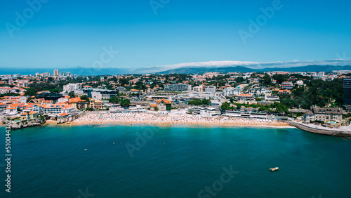 Drone aerial view of unidentifiable sunbathers at Praia da Conceicao beach in Cascais, Portugal