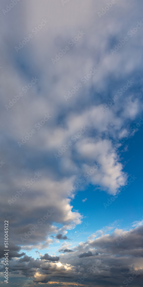 Obraz premium Fantastic thunderclouds at sunrise, vertical panorama