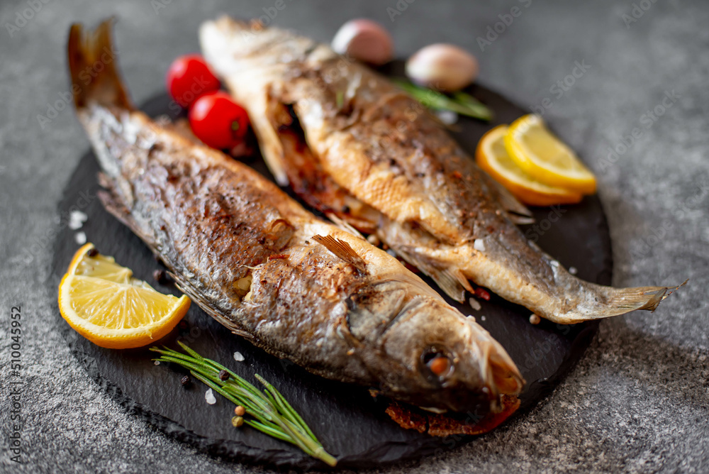 Baked sea bass fish on a stone background Baked sea bass fish on a stone background