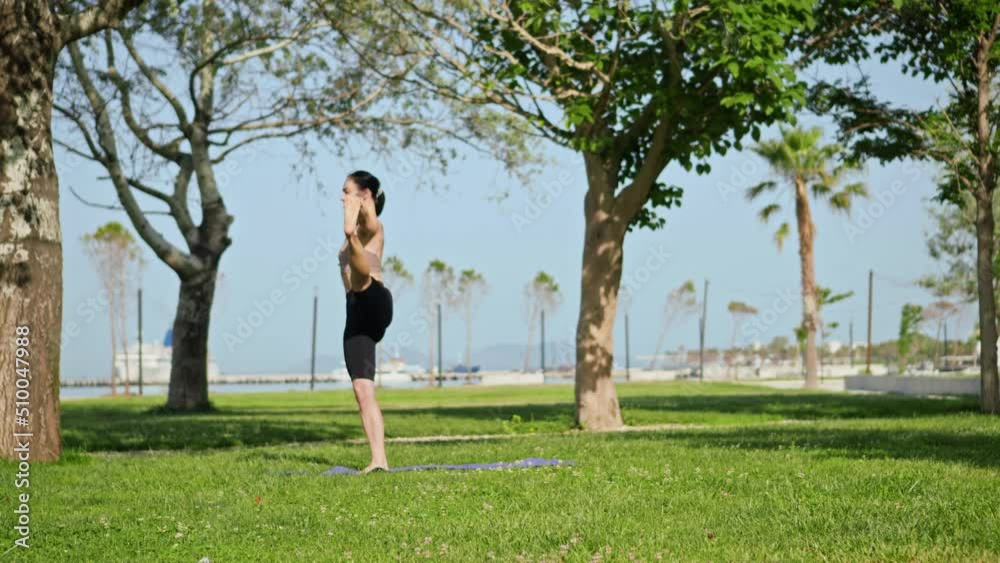 a young woman doing fitness, yoga, active exercises and stretching in the city park in the early morning. Healthy beautiful life by the sea, summer in the mountains a young woman doing fitness, yoga, active exercises and stretching in the city park in the early morning. Healthy beautiful life by the sea, summer in the mountains