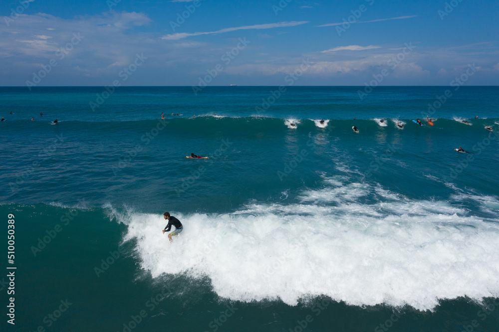 Haifa / Israel - Oct 30 2020 Drone view of surfer raiding a wave  in Bat Galim Haifa, surf time.