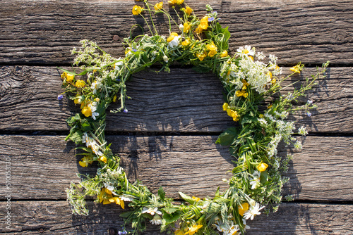 Midsummer crown, wreath of wildflowers on wooden background. Top view, copy space