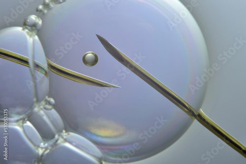 Ovum with a needle for artificial insemination or in vitro fertilization. The concept of genetic engineering and artificial insemination or infertility treatment.