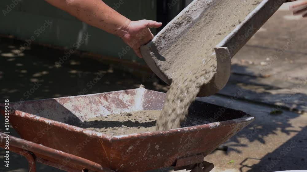 Man working with concrete mixer. The concrete mix is fed from a concrete mixer. Man working with concrete mixer. The concrete mix is fed from a concrete mixer.