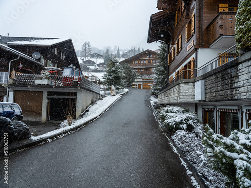 Grindelwald village street and Swiss houses during snowfall in Switzerland