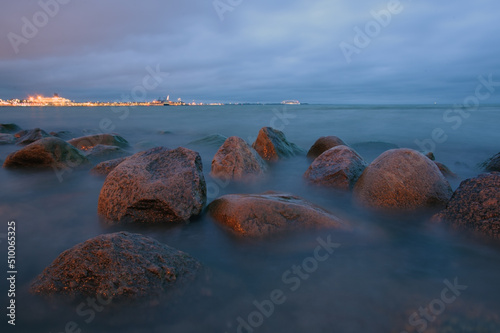 Beach landscape with stones in rainy evening