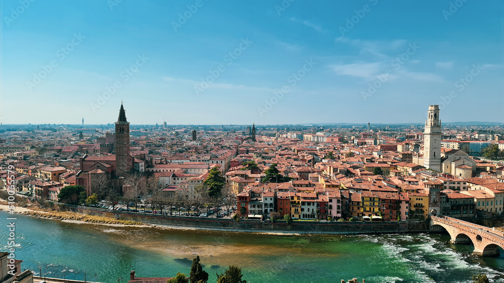 Verona, Italy - March 19, 2022: Aerial view of Verona historical city centre, Ponte Pietra bridge across Adige river, Verona Cathedral, Duomo di Verona, red tiled roofs, Veneto Region, Italy.