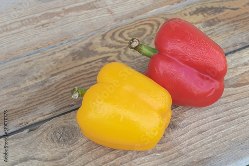 Closeup shot of red and yellow peppers on wooden table