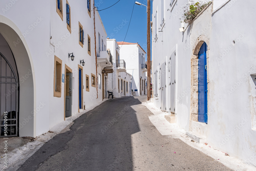Greece, Kythira island. Empty narrow street at Chora town. Traditional white color wall building