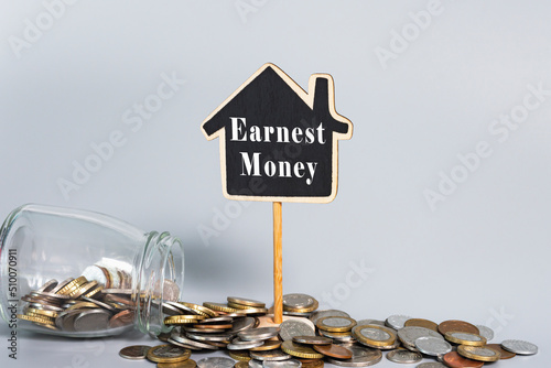 Reverse Mortgage text on wooden house model with coins in a glass jar.