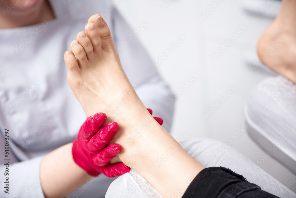 Close up on a podiatrist hands treating feet during procedure Close up on a podiatrist hands treating feet during procedure