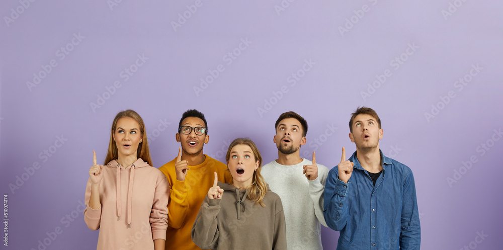 © Studio Romantic - Group of different mixed race multiethnic people struck by amazing idea and bright solution standing on color background and pointing index fingers up with open mouths and surprised facial expressions © Studio Romantic - Group of different mixed race multiethnic people struck by amazing idea and bright solution standing on color background and pointing index fingers up with open mouths and surprised facial expressions