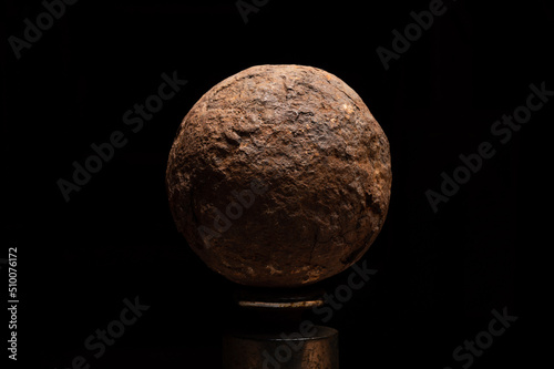 Moody image of old vintage antique cannon ball, steel rusty ball. photo