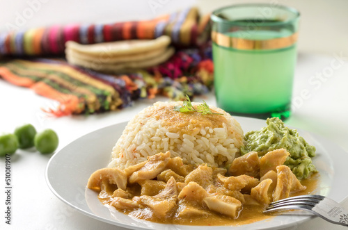 Tiras, plato típico tradicional de guatemala hecho con panza de res en una salsa de miltomate en el caso de esta foto, que se acompaña con arroz y guacamol y tortillas de maíz photo