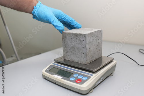 Modern laboratory for testing road samples and materials concept. A sample of cement concrete on an electronic scale.