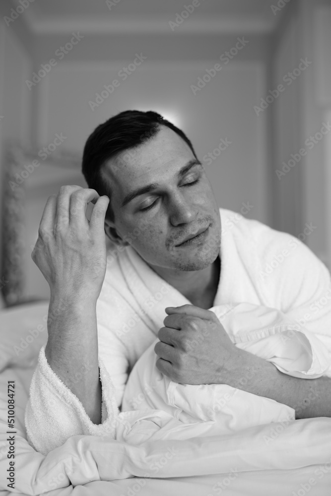 in the photo, a smug man in a bathrobe in hotels lying down enjoying the view from the window in the photo, a smug man in a bathrobe in hotels lying down enjoying the view from the window