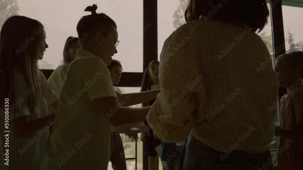 Cruel bullies offending classmate in school hallway. Teenagers pushing boy. Cruel bullies offending classmate in school hallway. Teenagers pushing boy.