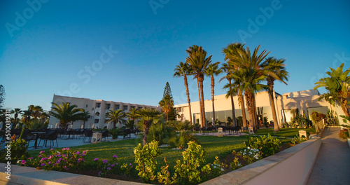 Resort garden with palm trees. Exclusive vacation destination, lifestyle, tourism. Tropical garden with green lawn. © RecCameraStock
