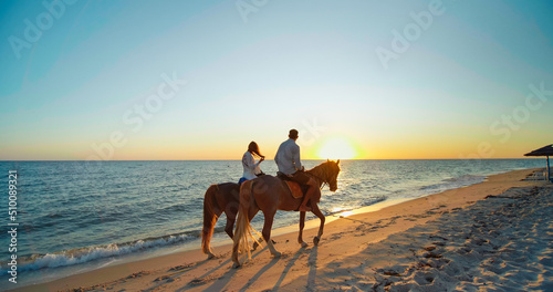 Monastir, Tunisia, 2022: Scenic, romantic view of a beach at sunset. Couple in love is enjoying holiday. Seashore with sun shining. Beautiful landscape, travel destination. photo