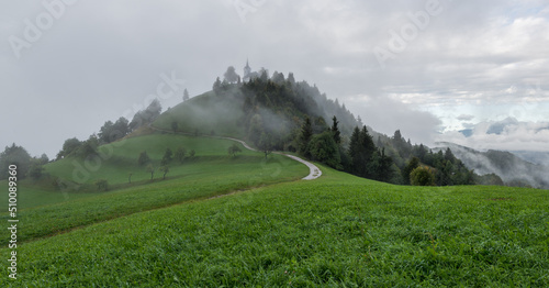 Church on top of the hill in Slovenian countryside photo