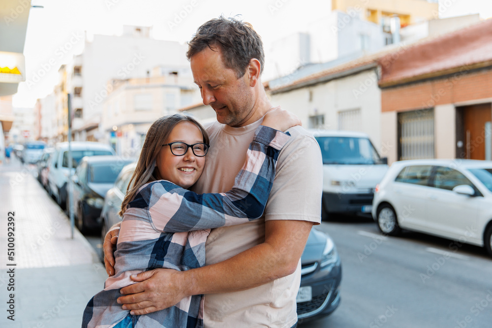 Dad hugs his daughter on a city street Dad hugs his daughter on a city street