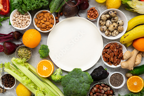 Balanced food background with vegetables and nuts and white plate