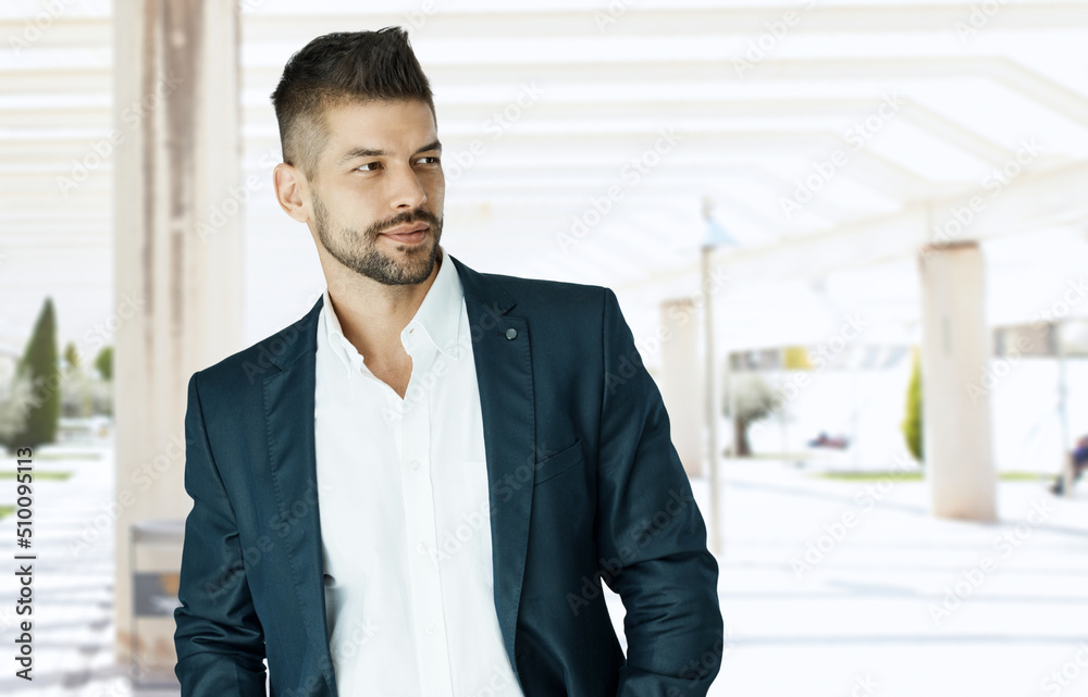 Fototapeta premium Dedicated young businessman in jacket looking away in office lobby. Man in business.
