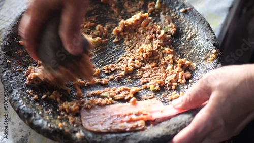 Preparing rujak petis.Rujak petis is traditional food from Java made from steamed mix vegetables, black sauce made from fried garlic, chillies, petis (black fermented shrimp paste) and ground peanuts photo