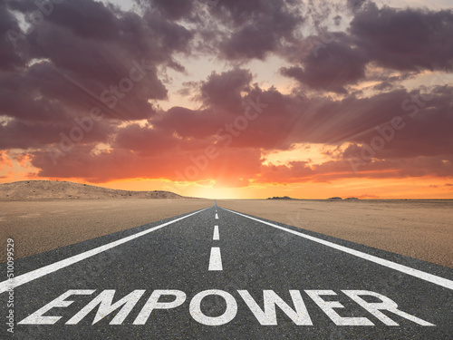 Empower text on a road for empowerment concept.