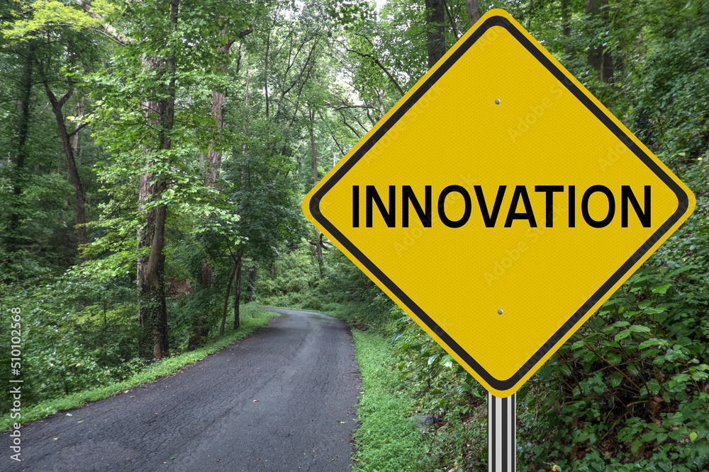 Innovation sign in the woods with road leading to future success.