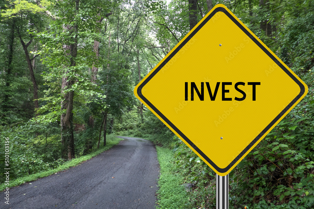 Invest sign with road in the woods leading to future gains.