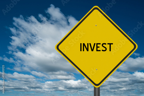 Invest highway sign on a blue sky background for motivation concept.