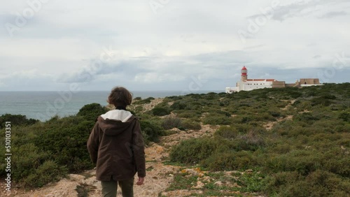 Boy traveler walking to Cape St. Vincent Lighthouse in Portugal