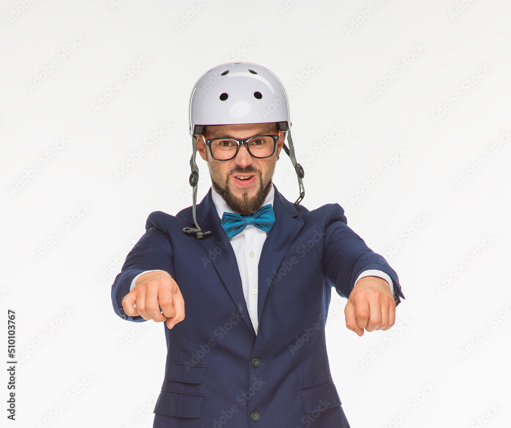 a cheerful guy poses in a white helmet and a blue jacket on a white background isolated in the studio. the guy shows a motorcycle. imitates riding a bike on a motorcycle a cheerful guy poses in a white helmet and a blue jacket on a white background isolated in the studio. the guy shows a motorcycle. imitates riding a bike on a motorcycle