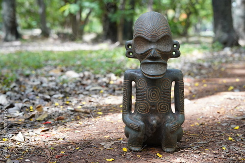 Taino Antique Stone Idol God Figure standing on the grown, close up. Taino Indian Mythology. photo