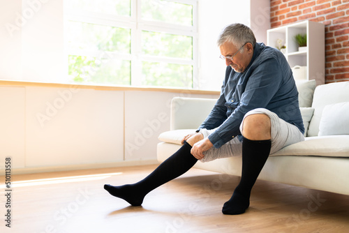 Man Putting On Medical Compression Stockings photo