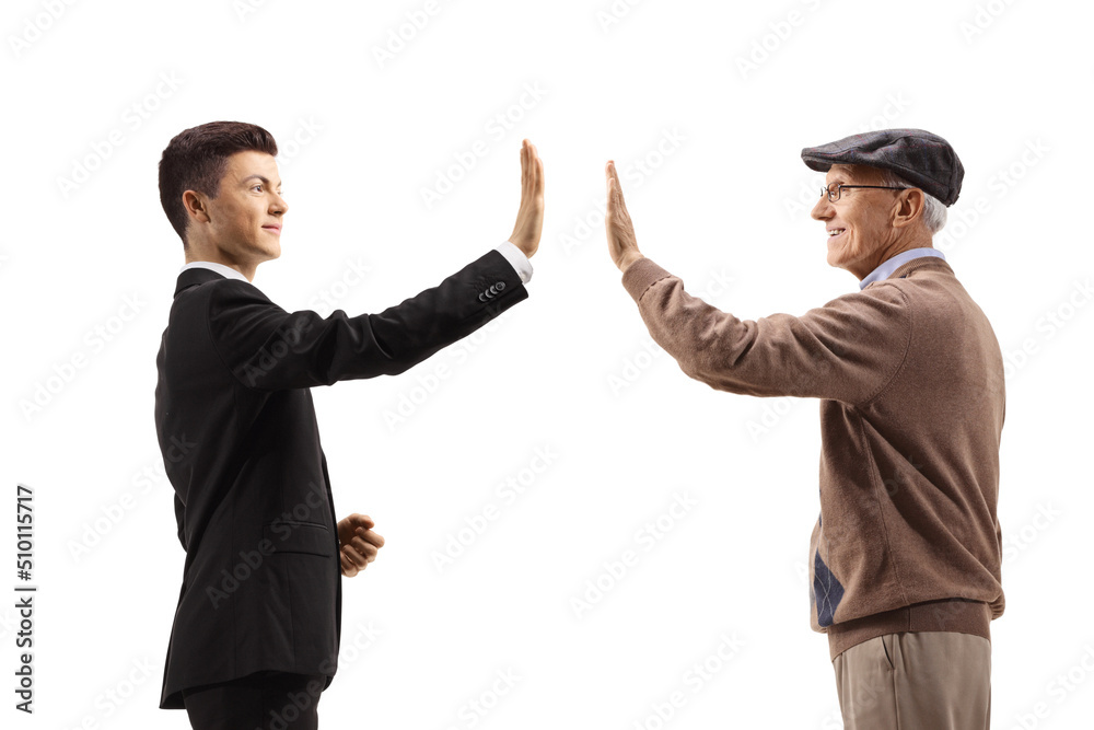 Profile shot of a young man in a suit greeting an elderly man with a high-five gesture Profile shot of a young man in a suit greeting an elderly man with a high-five gesture