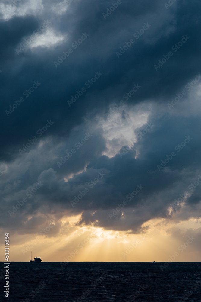 Intense sun rays coming through the clouds over the ocean in Belize Intense sun rays coming through the clouds over the ocean in Belize