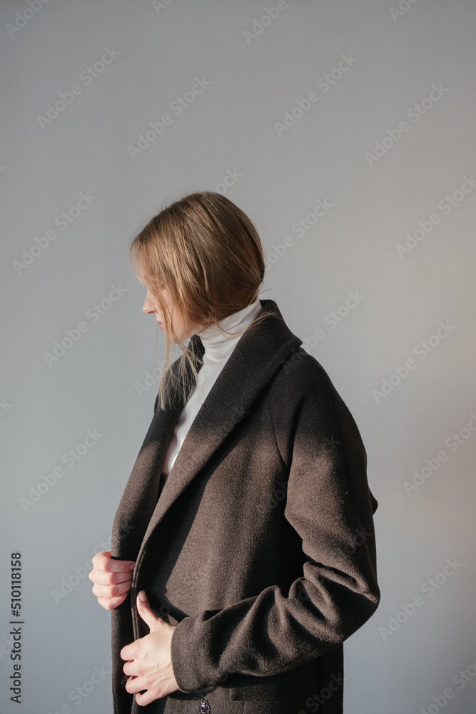 black coat and white golf on a blonde girl in a bright room black coat and white golf on a blonde girl in a bright room
