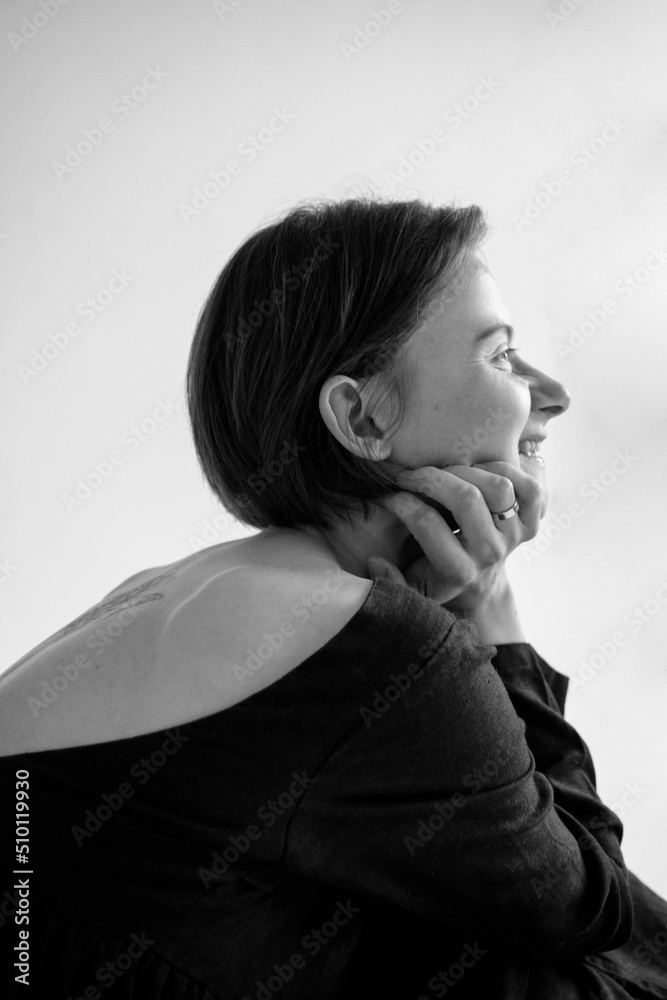 black and white portrait in profile of a young laughing mother in a light studio black and white portrait in profile of a young laughing mother in a light studio