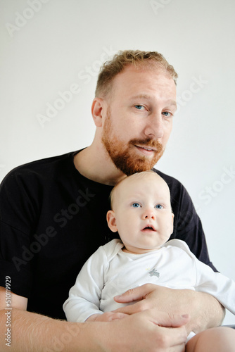 portrait of a young dad holding a little daughter in the studio photo