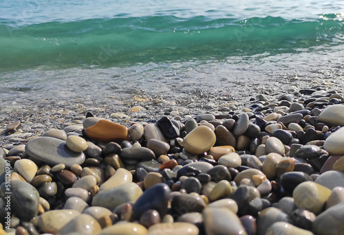 Pebble gravel sea stones natural beach background. Partly blurred out of focus.