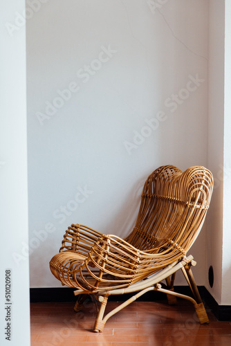 Fashionable wicker chair in the corner of a room