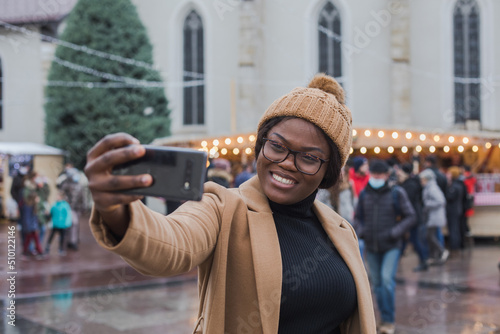 woman tourist doing selfie in Christmas market in France, Europe photo