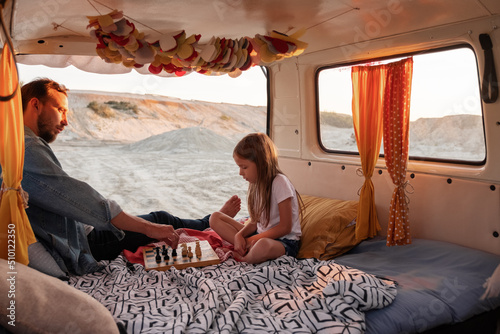 Dad and child playing chess during road trip
