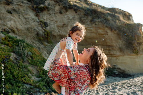 Mom lifts happy daughter in the air photo