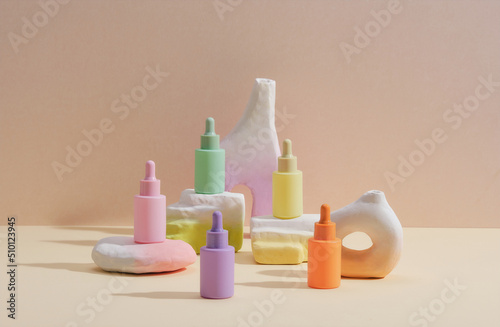 Essential oil bottle on the gray block against beige background photo