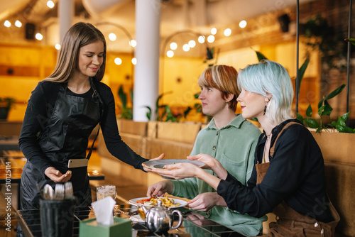 Waitress catering clients in restaurant 