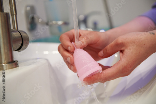 Young woman cleaning menstrual cup 